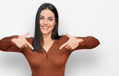 Gündelik kıyafetler giyen, kendine güvenen, gülümseyen, kendini gururlu ve mutlu gösteren genç İspanyol kadın.. 