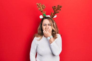 Orta yaşlı, beyaz bir kadın şirin Noel geyiği boynuzları takıyor. Kokuşmuş ve iğrenç bir koku alıyor. Dayanılmaz bir koku. Kötü kokuyor. 