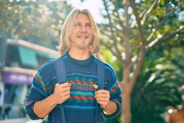 Genç İskandinav öğrenci parkta mutlu bir şekilde dikiliyor..