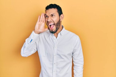 Sakallı, iş gömleği giymiş İspanyol bir adam el ele tutuşup bağırıyor. iletişim konsepti. 