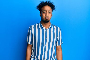 Sakallı, sıradan çizgili tişörtlü, komik yüzlü, yanakları şişen genç Afro-Amerikalı bir adam. Havayla şişmiş ağız, çılgın bir ifade.. 