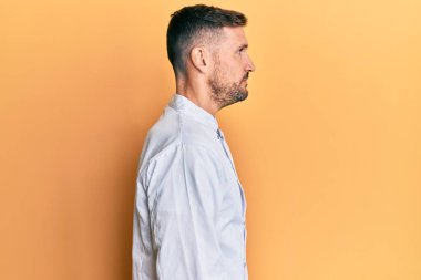 Sakallı, profesyonel bir aşçı üniforması giyen, rahat bir görünüm takınan, kendine güvenen bir gülümsemesi olan yakışıklı bir adam.. 