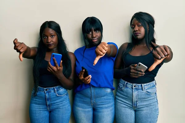 Τρεις Νεαροί Αφροαμερικανοί Φίλοι Χρησιμοποιούν Smartphone Δείχνοντας Δυστυχισμένοι Και Θυμωμένοι — Φωτογραφία Αρχείου