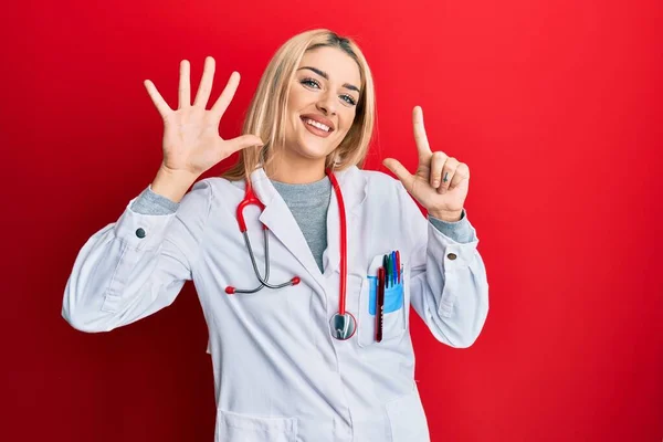 Doktor Üniforması Steteskop Giyen Genç Beyaz Kadın Yedinci Parmaklarını Gösterip — Stok fotoğraf