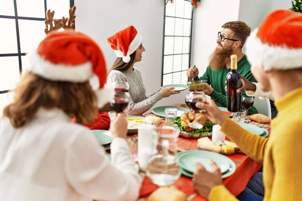 一群年轻人笑着高兴地在家里吃圣诞大餐 — 图库照片