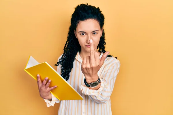 Young Hispanic Woman Curly Hair Holding Book Showing Middle Finger — Stockfoto