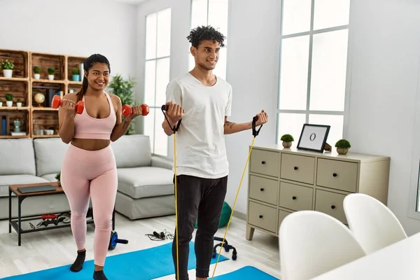 Young Latin Couple Smiling Happy Training Using Elastic Band Dumbbells — ストック写真