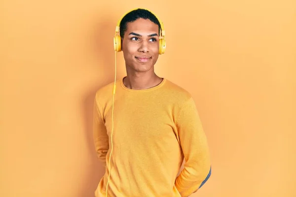 Joven Afroamericano Chico Escuchando Música Usando Auriculares Sonriendo Mirando Hacia —  Fotos de Stock