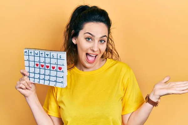 Jovem Hispânica Segurando Calendário Cardíaco Celebrando Realização Com Sorriso Feliz — Fotografia de Stock