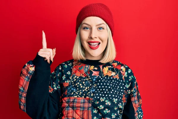 Junge Blonde Frau Mit Wollener Wintermütze Zeigt Mit Erhobenem Zeigefinger — Stockfoto