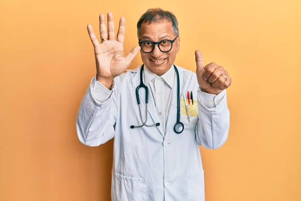 中世インド人男性身に着けています医師コートと聴診器表示し 指で指差し込みます番号6ながら笑顔自信と幸せ — ストック写真