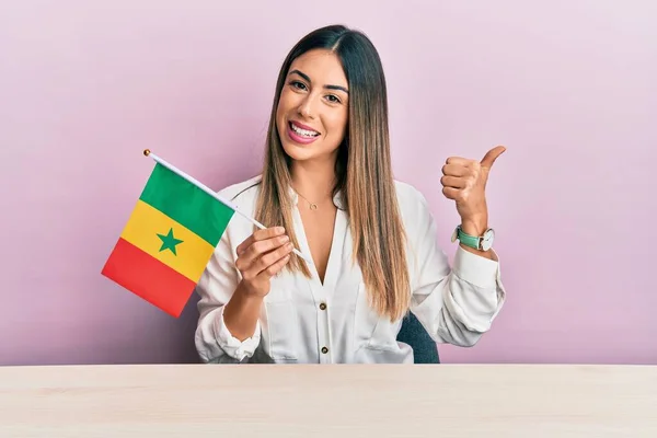 Mujer Hispana Joven Sosteniendo Bandera Senegal Sentada Mesa Apuntando Con —  Fotos de Stock