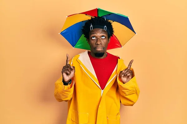 Jovem Afro Americano Vestindo Capa Chuva Amarela Apontando Para Cima — Fotografia de Stock