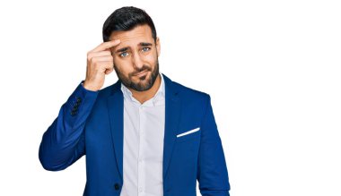 Alnındaki sivilceden mutsuz olduğunu gösteren iş ceketi giymiş genç İspanyol bir adam. Siyah başlıklı çirkin bir enfeksiyon. sivilce ve deri problemi 