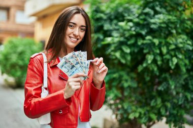 Genç İspanyol kadın gülümsüyor. Mutlu bir şekilde Peru banknotlarını sayıyor..