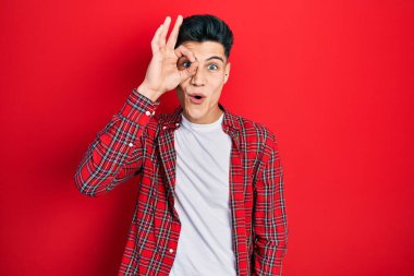 Gündelik kıyafetler giyen genç İspanyol adam şaşırmış yüz ifadesiyle şok olmuş, parmaklarından bakan gözler. İnançsız ifade. 