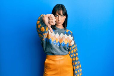 Gündelik kazak giyen genç İspanyol kadın mutsuz ve kızgın görünüyor. Reddedilmiş ve olumsuz hareketler yapıyor. kötü ifade. 