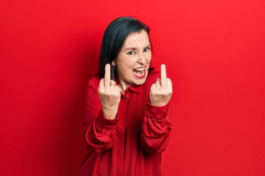 Middle age hispanic woman wearing casual clothes showing middle finger doing fuck you bad expression, provocation and rude attitude. screaming excited 