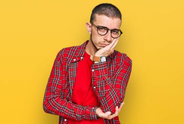 İspanyol genç adam günlük kıyafetler giyip kollarını kavuşturarak depresyondan sıkılmış ve yorgun görünüyor.. 