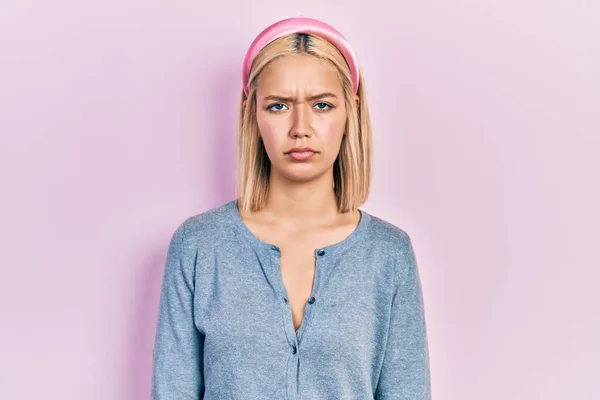 美しいブロンドの女性ピンクの背景懐疑的で神経の上に立って 問題のために動揺を眉をひそめて 否定的な人 — ストック写真