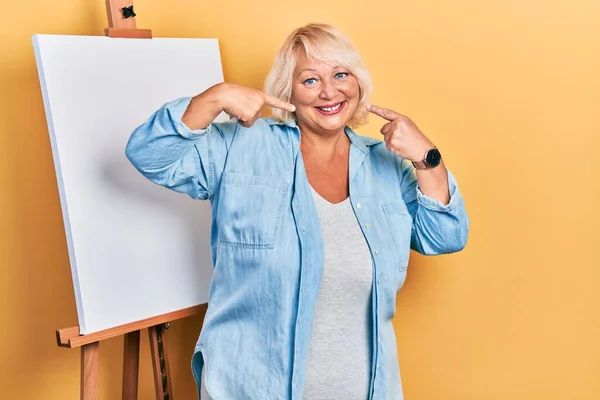 Middle Age Blonde Woman Standing Painter Easel Stand Smiling Cheerful — Stock Photo, Image