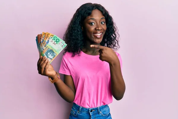 Hermosa Mujer Joven Africana Sosteniendo Dólares Australianos Sonriendo Feliz Señalando — Foto de Stock