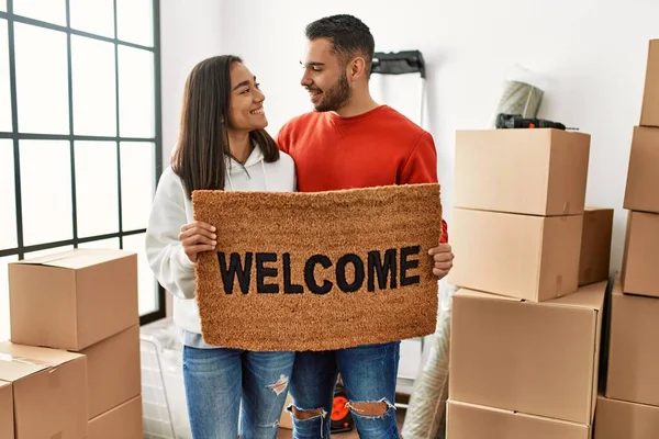 Young Latin Couple Smiling Happy Holding Welcome Doormat New Home — Stock Photo, Image
