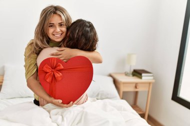 Genç bir kadın yatak odasında sevgilisine sevgililer günü hediyesiyle sürpriz yapıyor..