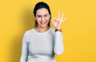 Gündelik kıyafetler giyen, gülümseyen genç İspanyol kadın el ve parmaklarıyla 