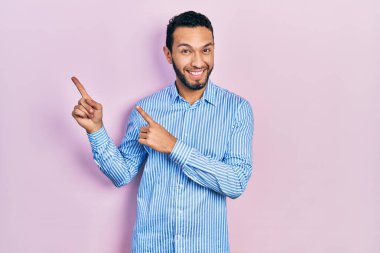 Sakallı, sıradan mavi tişörtlü, gülümseyen ve kameraya bakan İspanyol bir adam.. 