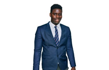 Yakışıklı iş adamı takım elbiseli ve kravatlı. Kameraya seksi bir ifadeyle bakıyor. Neşeli ve mutlu bir yüzü var.. 