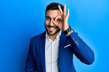 Genç İspanyol iş adamı iş ceketi giyiyor. El hareketleriyle gülümsüyor, gözleriyle mutlu yüzlere bakıyor.. 