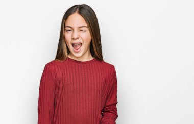 Güzel, esmer, sıradan bir kazak giyen küçük kız kameraya seksi bir ifadeyle bakıyor, neşeli ve mutlu bir yüzle.. 