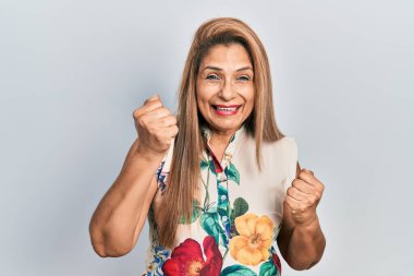 Orta yaşlı İspanyol kadın gündelik kıyafetler giyip gururla bağırıyor zaferi ve başarıyı kutluyor. 