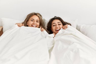 Genç, güzel bir çift yatakta uzanıyor ve evde battaniyeyle örtüyor..