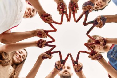 Bir grup genç arkadaş parmak ve ellerle zafer işareti yapıyor..