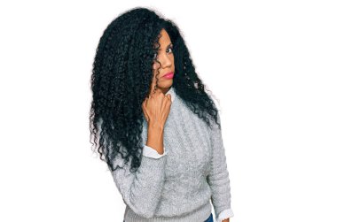Orta yaşlı Afro-Amerikan kadın, sıradan kıyafetler giyip, senin jestini, şüpheli ifadesini izleyerek, gözünün içine bakıyor. 