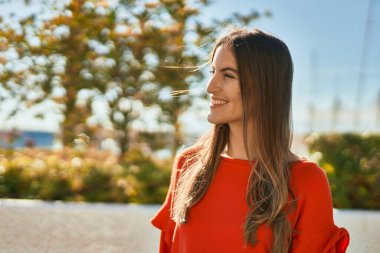 Genç İspanyol kadın gülümseyerek şehirde mutlu mesut dikiliyor..