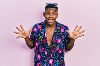 Havai gömleği ve güneş gözlüğü takan genç siyahi adam çılgın kutlamalar yapıyor ve kolları açık ve gözleri açık heyecanla haykırarak başarıdan hayrete düşüyor. Kazanan konsept 