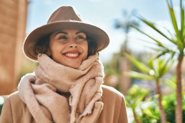 Şık giyinen genç İspanyol kadın şehirde dikiliyor..