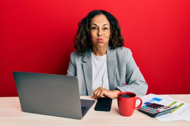 Ofiste çalışan orta yaşlı güzel bir kadın komik suratlı bir fincan kahve şişiren yanak içiyor. Havayla şişmiş ağız, çılgın bir ifade.. 