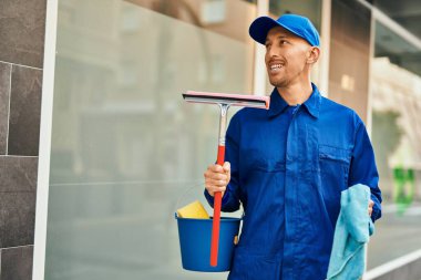 Beyaz tenli, cam yıkayıcı şehirde mutlu bir şekilde dikiliyor..