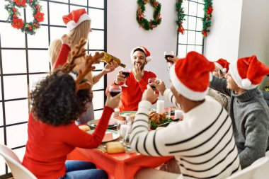 Bir grup genç arkadaş Noel yemeği yiyor ve evde şarap döküyorlar..