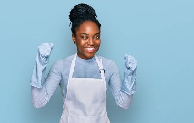 Önlük giymiş genç Afrikalı Amerikalı kadın gururla bağırıyor zaferi ve başarıyı kutluyor. 