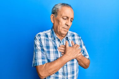 Son sınıf İspanyol 'u sıradan kıyafetler giymiş göğsünde elleri göğsünde gülümseyen, yüzünde minnet dolu bir jest ile gözleri kapalı. sağlık kavramı. 