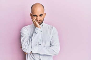 Günlük kıyafetler giyen genç İspanyol adam kollarını kavuşturarak depresyondan sıkılmış ve yorgun görünüyor.. 