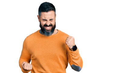 Sıradan bir kazak giyen İspanyol adam kolları havada ve gözleri kapalı bir şekilde başarıyı kutluyor ve şaşırıyor. Kazanan konsept. 