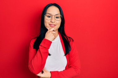 Burnuna piercing takan, sıradan bakışlar atan, kameraya kendinden emin, kolları çapraz ve çenesi havada gülümseyen güzel İspanyol bir kadın. Olumlu düşünmek. 