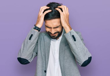 Genç İspanyol bir adam iş kıyafetleri giyip baş ağrısı çekiyor. Acı ve migren yüzünden çaresiz ve stresli. Eller başının üstünde.. 