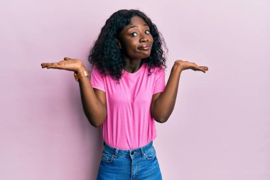 Güzel, Afro-Afrikalı bir kadın. Sıradan pembe tişörtler giyiyor. Hiçbir fikri yok.. 